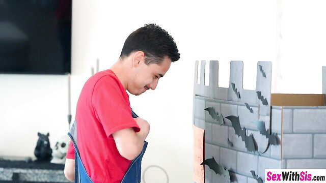 Handsome Latino man in red overalls peeks at Halloween castle playhouse