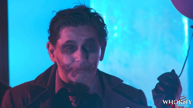 Joker-faced man in makeup holding balloon, Whorny Films adult scene