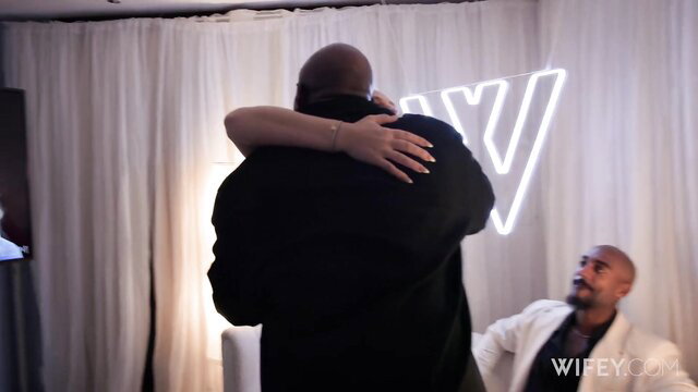 Elana Bunnz hugged from behind by black man at Wifey event
