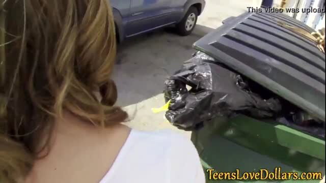 Teen girl in white tank top near outdoor trash bin