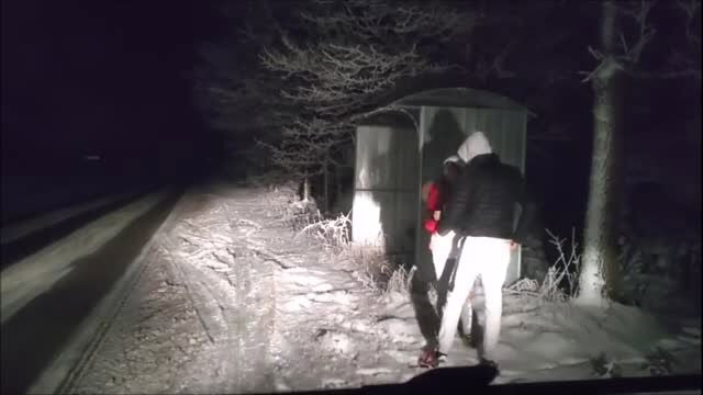 Amateur night sex outdoors by road, man fucks woman in red jacket against shed