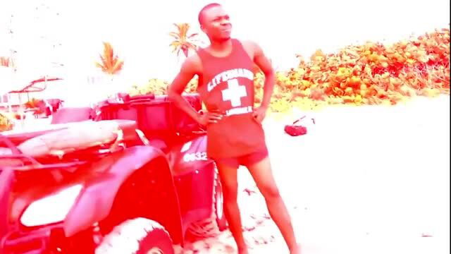 Lifeguard in red uniform standing next to ATV on beach