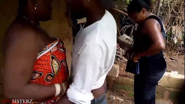 African women in revealing outfits standing outdoors with man in white shirt
