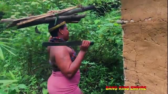 Busty ebony BBW hunter carrying logs and machete in forest